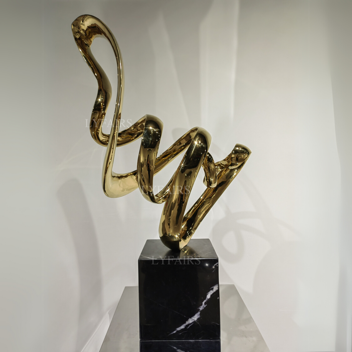 Sculpture artistique inspirée d'un ruban en acier inoxydable plaqué or